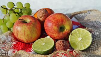 still life with apples, grapes, lychees and lime
