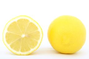 whole lemon and half of it on a white background