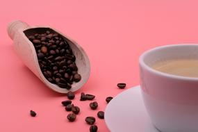 cup of coffee and coffee grains in a scoop