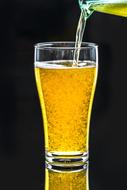 beer pouring to glass at black background