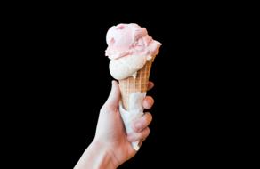 pink ice cream in a waffle cone in hand