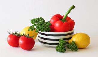 Colorful vegetables in the black and white bowl at white background