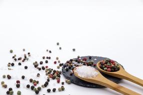 sea salt and peppercorns on a wooden spoons