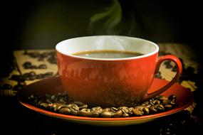 Coffee in red Cup and beans on saucer