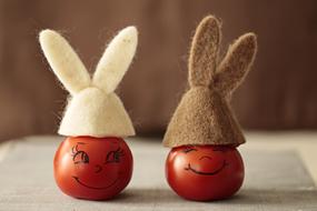 two Tomatoes with faces in ear hats