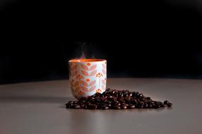 hot coffee mug and sprinkled coffee beans