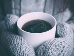 hot coffee in hands in mittens close-up