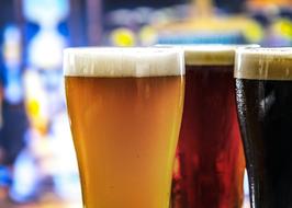 three glasses with beer on a blurred background