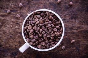 white cup with coffee beans
