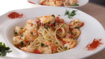 shrimp pasta in a plate in a restaurant