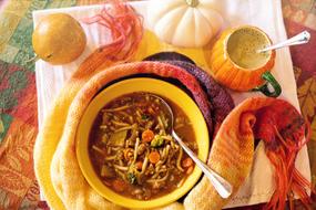 noodle soup in a plate and a colorful scarf on the table