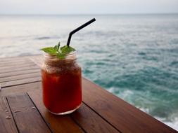 cocktail in jar on table at sea