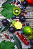 plum, lime, red currant and green leaves on the table