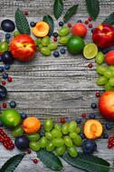 colorful Fruits and leaves in circle on wooden surface