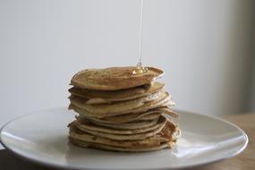 Honey pouring on top of stack of Pancakes
