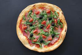 photo of italian pizza with olives, tomatoes and arugula