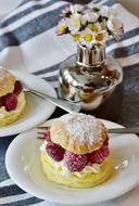 Puff Pastry mini cakes with raspberry on white plates