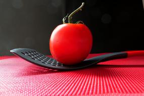 red tomato on black kitchen tool