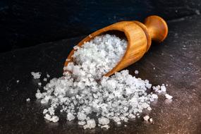 sea salt in a wooden spoon on the surface