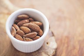 brown almonds in a white bowl