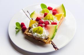 fruits and berries with cream on waffles