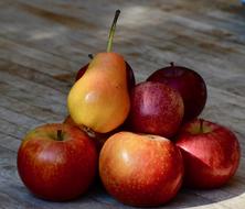 Pear at top of pile of apples