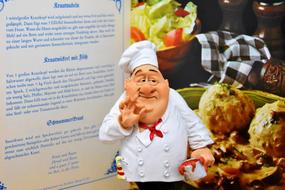 ceramic figurine of a cook on a menu background