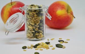 pine nuts, Sunflower and Pumpkin Seeds in jar and Apples on table
