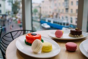 cake and macaroons on a plate in a pastry shop