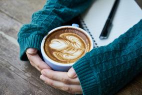 Coffee in Cup on table in female hands