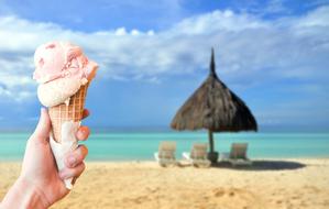 strawberry ice cream cone on a tropical beach