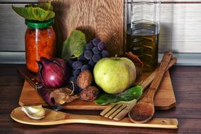 Colorful grapes, vegetables, wooden spoons and cutting boards on the kitchen table