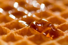 Syrup pouring on Belgian Waffle, macro