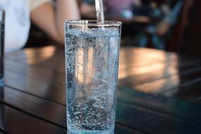 pour mineral water into a glass