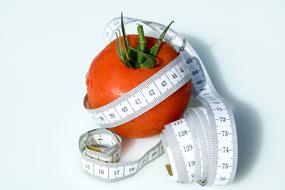 red tomato and white measuring tape