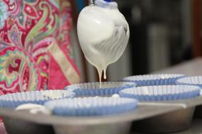 cupcake dough in molds close-up on blurred background
