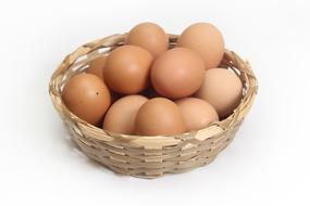 brown eggs in a basket on a white background