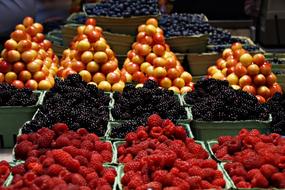 raspberries, blackberries and yellow plums on the market