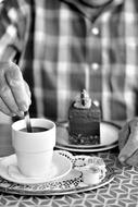 monochrome picture of man drinking a Coffee Cup and cake