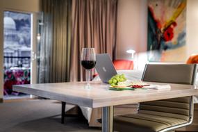 wine and laptop on the table in the hotel room