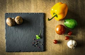 top view of ripe vegetables and spices on a black board on the table