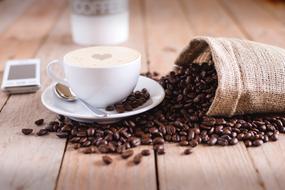 Coffee beans and drink on wooden table
