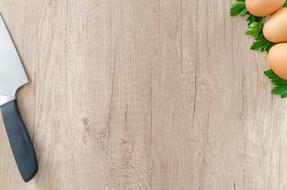 Knife and eggs on Wooden board, background