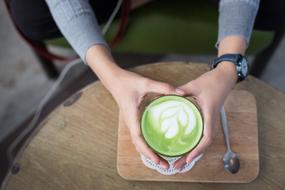 hot matcha latte in hands