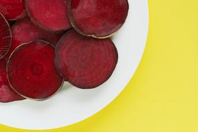 burgundy sliced beets on a white plate