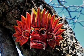 Colorful and beautiful, wooden mask on the tree, with the branches, in Sri Lanka