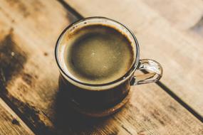 a cup of hot coffee on a wooden table
