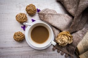 Drink in white Cup and rope balls on wooden table