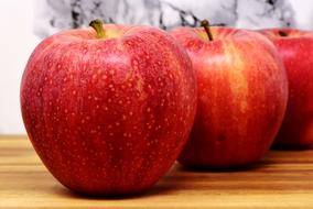 red ripe apples on wood board