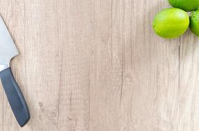 Knife and limes on cutting wooden board